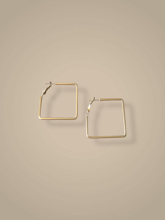 Gold square hoop earrings on a beige background
